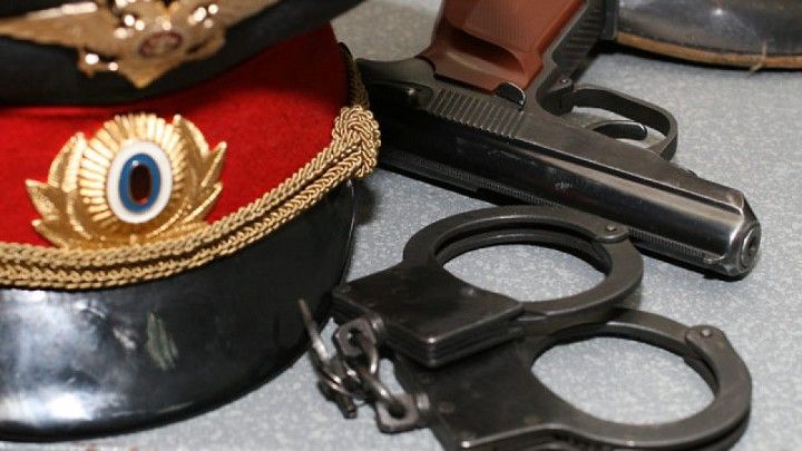 кашкет, наручники і пістолет