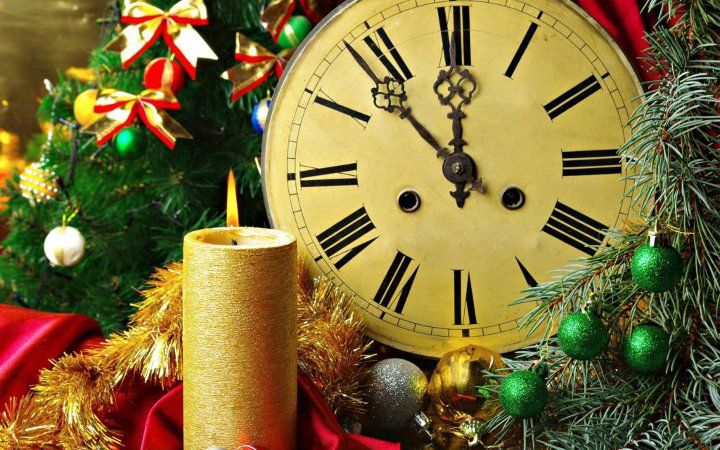 свічка, новорічний вінок і годинник