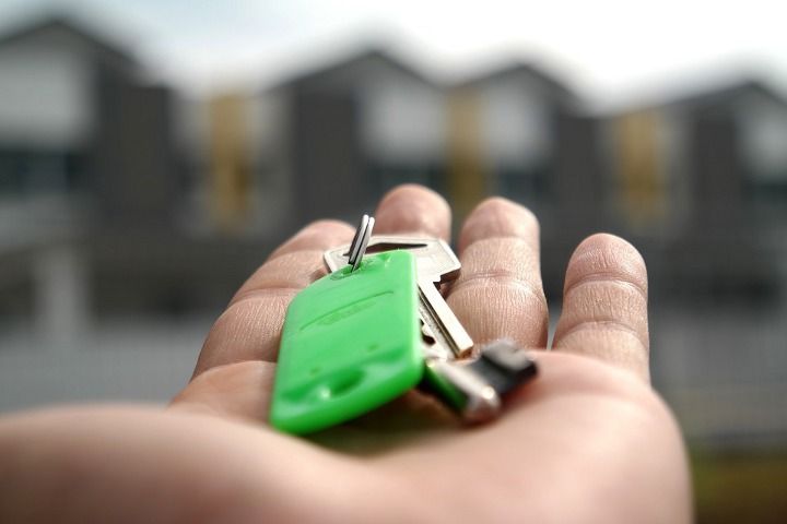 рука з ключами на тлі багатоквартирних будинків
