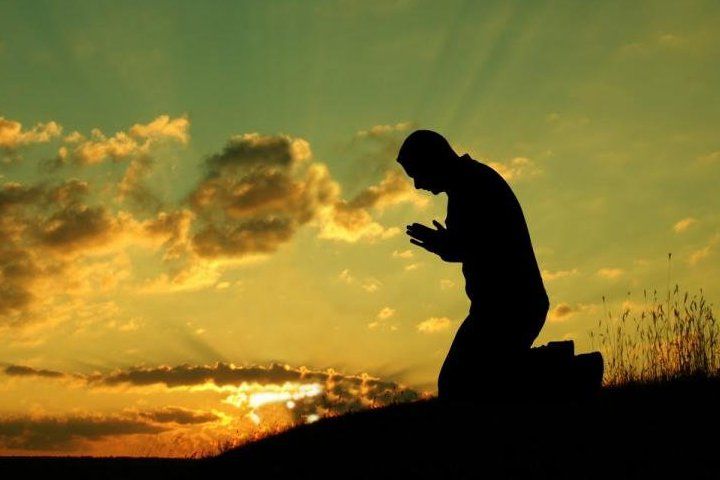 чоловік молиться на світанку
